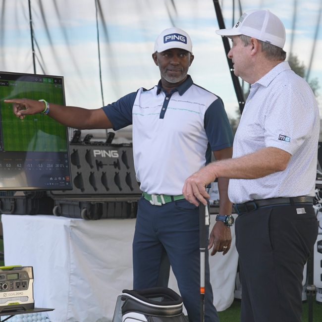 A clubfitter with laptop computer analyzing a golfer's ball flight.