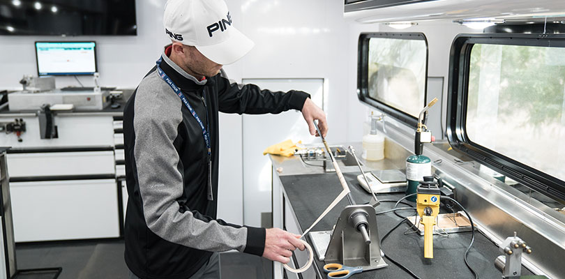 PING Tour technician applies grip tape to a shaft